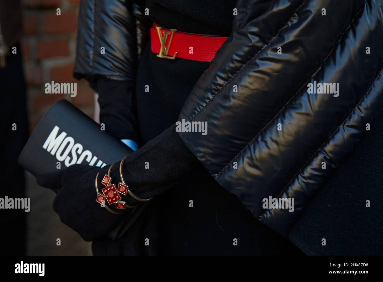 MILANO, ITALIA - 23 FEBBRAIO 2022: Uomo con borsa Moschino e cintura in pelle rossa Louis Vuitton prima della sfilata di moda Fendi, Milan Fashion Week Street Style Foto Stock