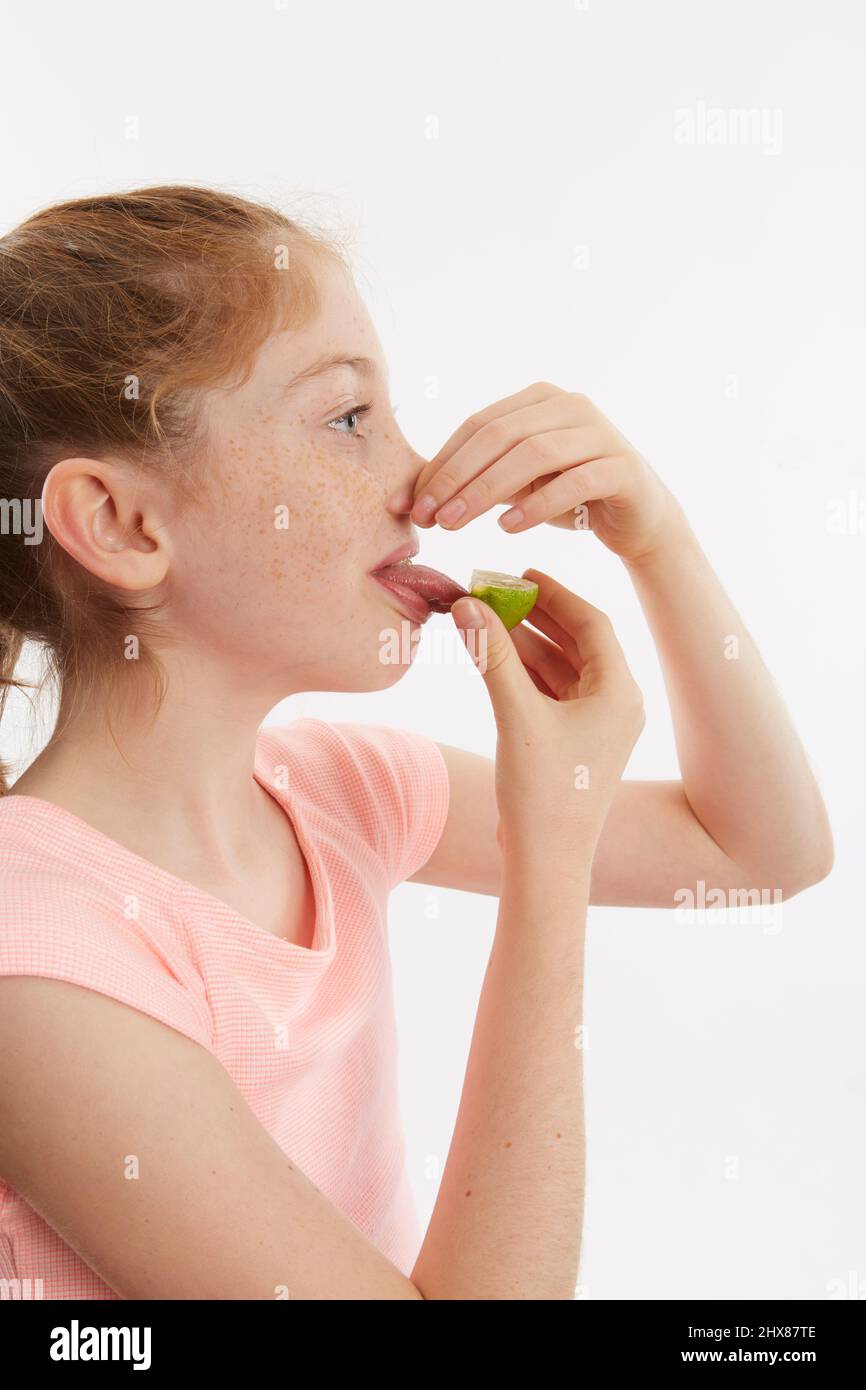 Cuneo di lime utilizzato per un test del gusto. Modello 10 anni. Foto Stock