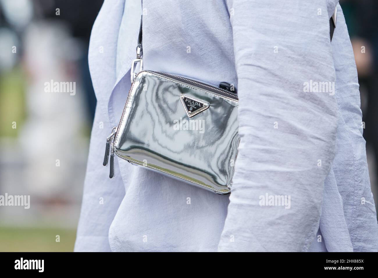 MILANO, ITALIA - 24 FEBBRAIO 2022: Uomo con borsa Prada metallizzata argento prima della sfilata di moda Emporio Armani, Milano Fashion Week Street Style Foto Stock
