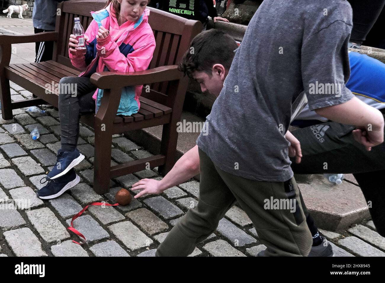 Jedburgh, giovedì 10 marzo 2022. Un ragazzo si avvicina per il Ba, mentre una giovane ragazza guarda avanti durante l'evento annuale 'Fastern Eve Handba' in High Street di Jedburgh, nei confini scozzesi, il 10 marzo 2022 a Jedburgh, Scozia. L'evento annuale, iniziato nel 1700, si svolge oggi e coinvolge due squadre, gli Uppies (residenti dalla parte più alta di Jedburgh) e i Doonies (residenti dalla parte più bassa di Jedburgh) che ottengono la palla alla parte superiore o inferiore della città. La palla, che è in pelle, farcita di paglia e decorata con nastri, è gettata nella folla per implorare Foto Stock