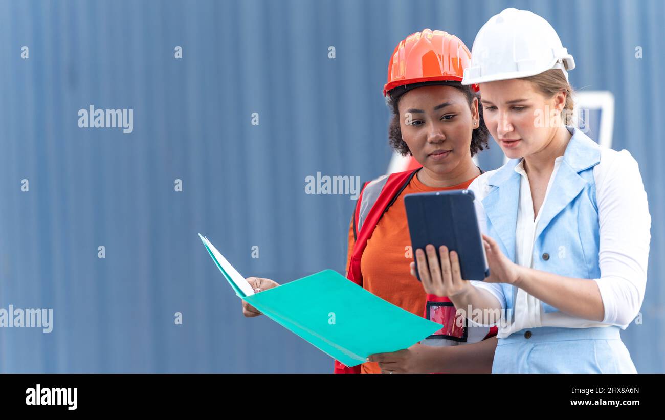 African american holding board file e report business logistic a Woman CEO in cargo container warehouse import and export Foto Stock