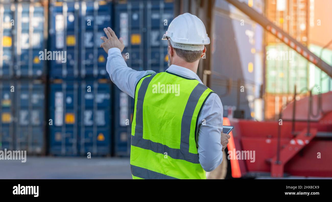 CEO o Manager in casco bianco con controllo tablet caricamento contenitori in magazzino , responsabile ispettore o supervisore di sicurezza in Container CustomTer Foto Stock