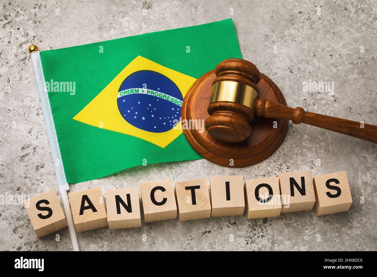 Bandiera brasiliana, giudice gavel e cubi di legno con testo, concetto sul tema delle sanzioni in Brasile Foto Stock