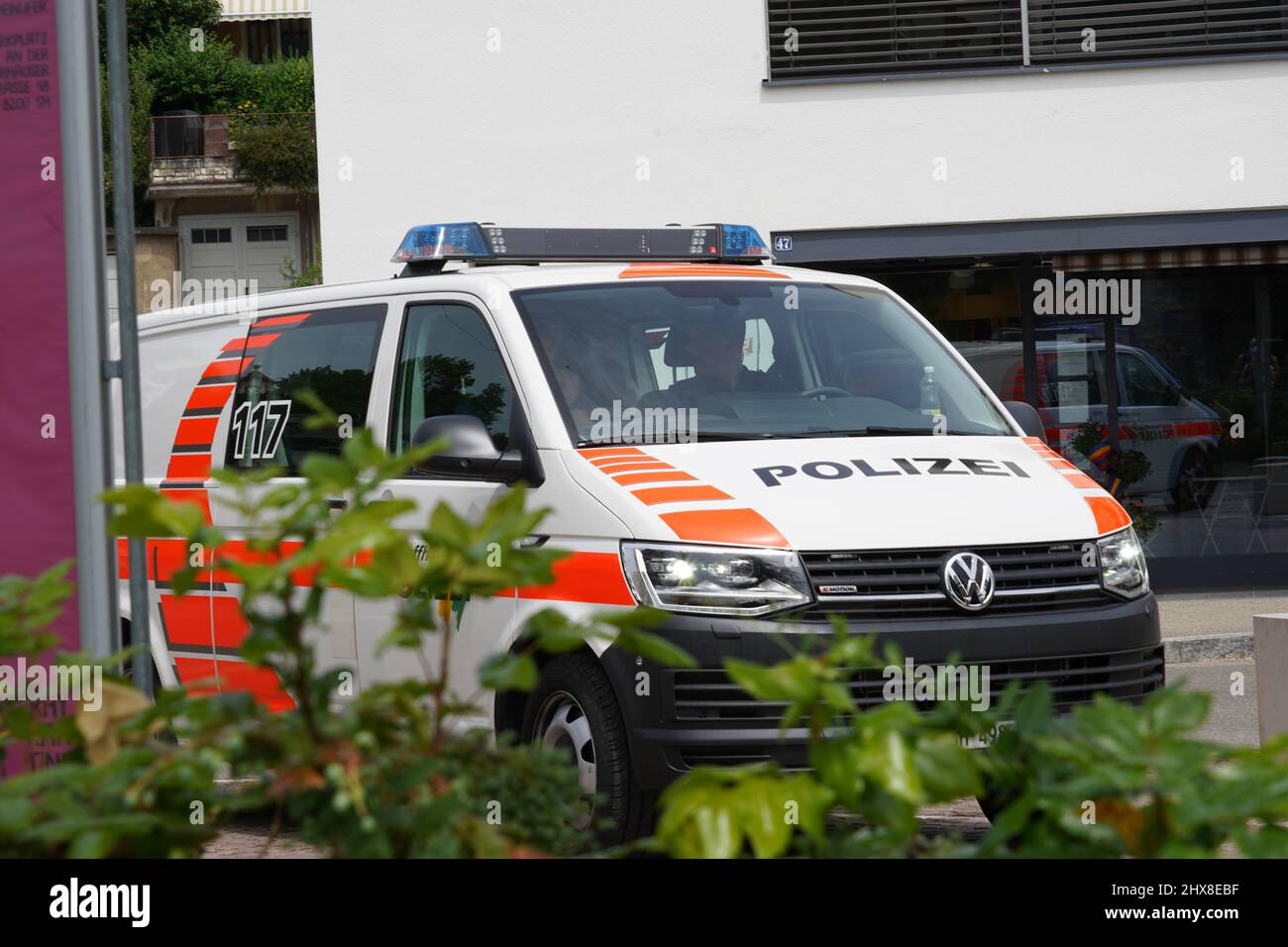 Una macchina della polizia che fa la guardia in città. L'auto di pattuglia è in arancione e bianco. Foto Stock