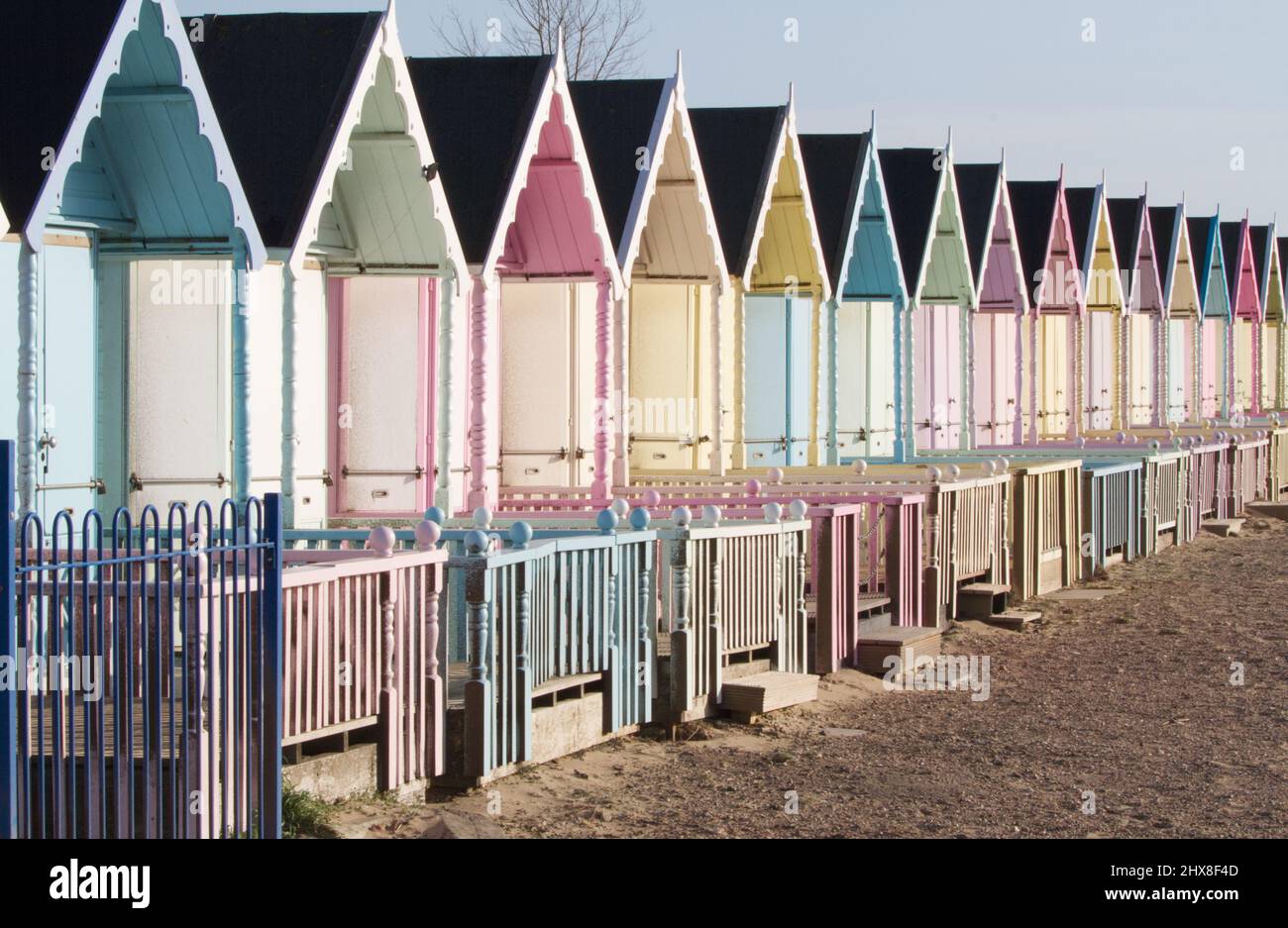 Colorate capanne sulla spiaggia in colori pastello a West Mersea sull'isola di Mersea nell'Essex Foto Stock