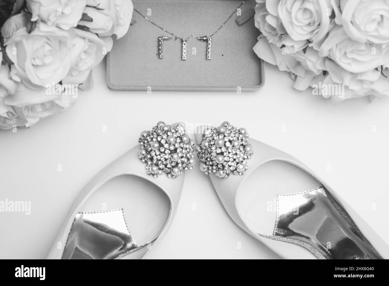 Accessori per matrimoni su sfondo bianco pulito. Scarpe, fiori e gioielli Foto Stock