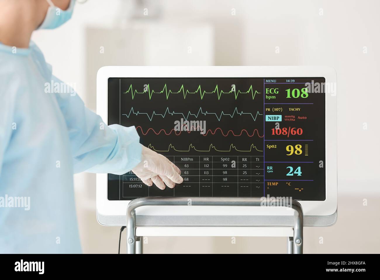 Medico vicino al monitor della frequenza cardiaca moderno in sala operatoria Foto Stock