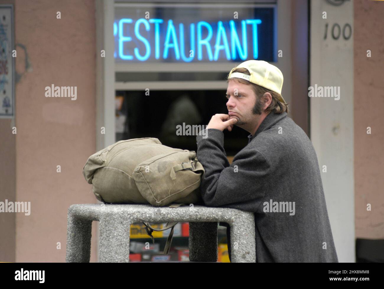 Giovane uomo in attesa di bus fuori ristorante in spiaggia di Maimi Foto Stock