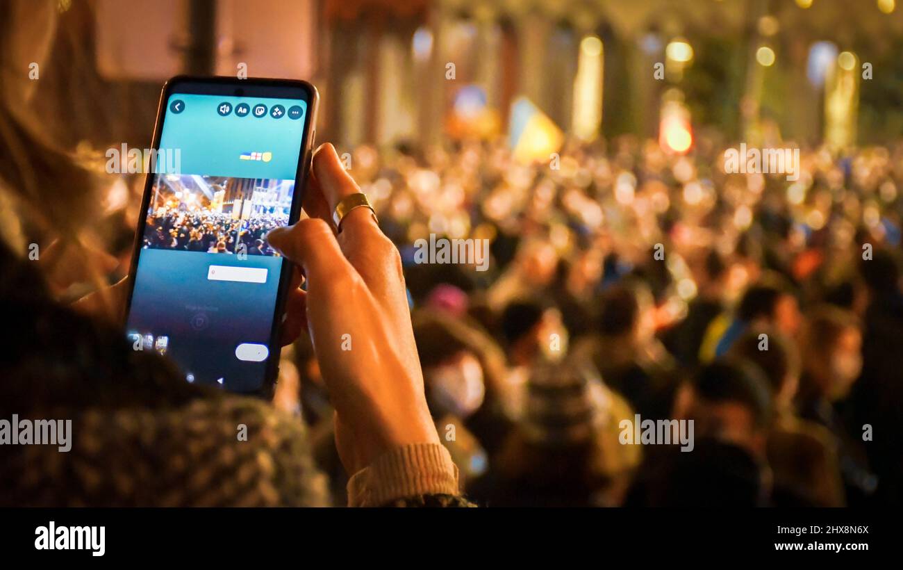 Tbilisi, Georgia - 1st marzo, 2022: Tipo di persona sul touch screen sullo smartphone per inviare notizie feed aggiornamento in protesta. L'esercito russo entrò in Ukrai Foto Stock