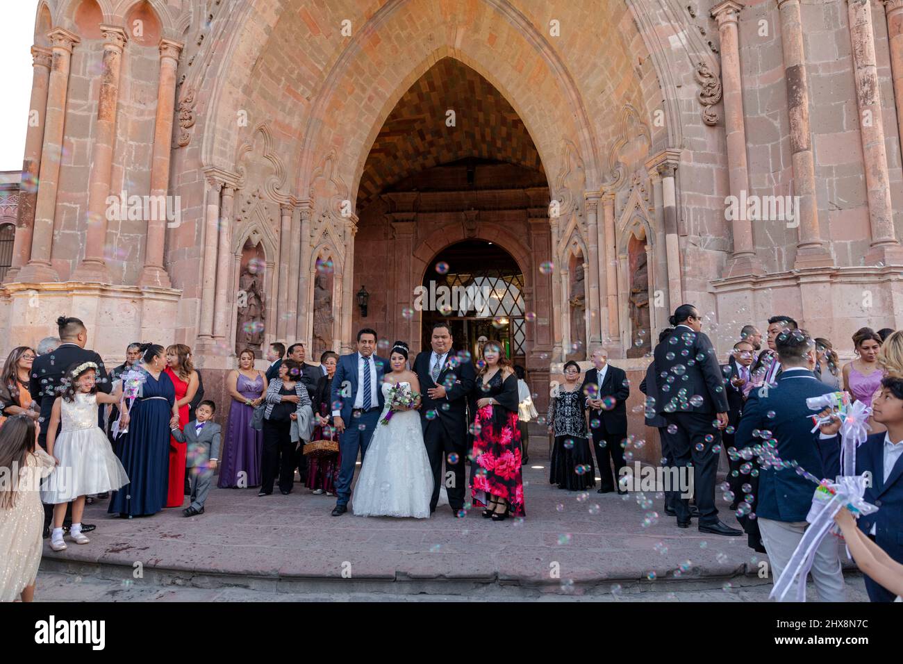 Messico, Guanajuato, San Miguel de Allende, festa di nozze che si posa sui gradini anteriori di una chiesa Foto Stock