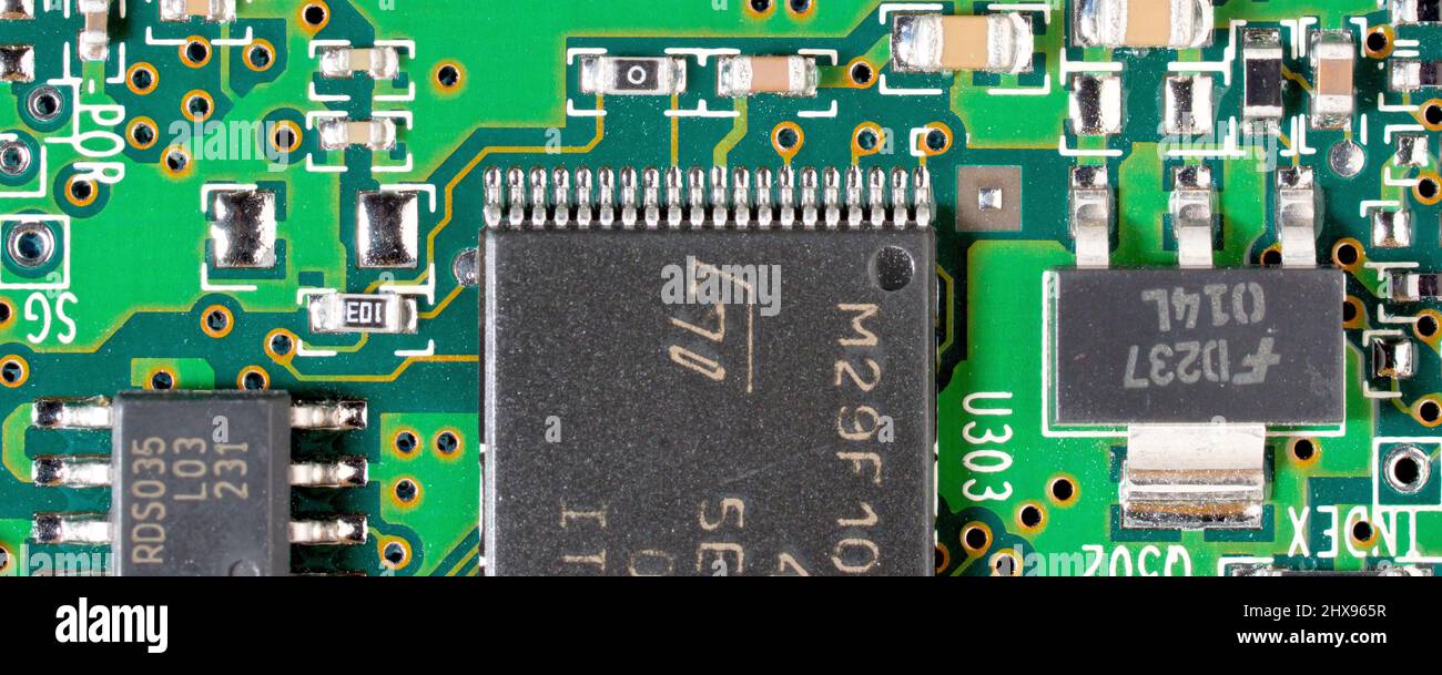 Primo piano di un circuito stampato di un computer, che mostra varie dimensioni di chip integrati e altri componenti elettronici. Foto Stock