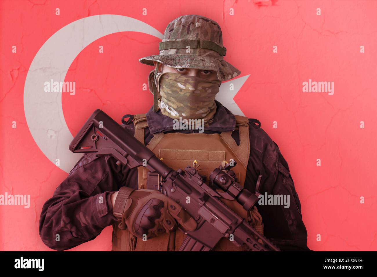 Soldato turco arrabbiato armato di fucile con bandiera della turchia come sfondo dietro Foto Stock