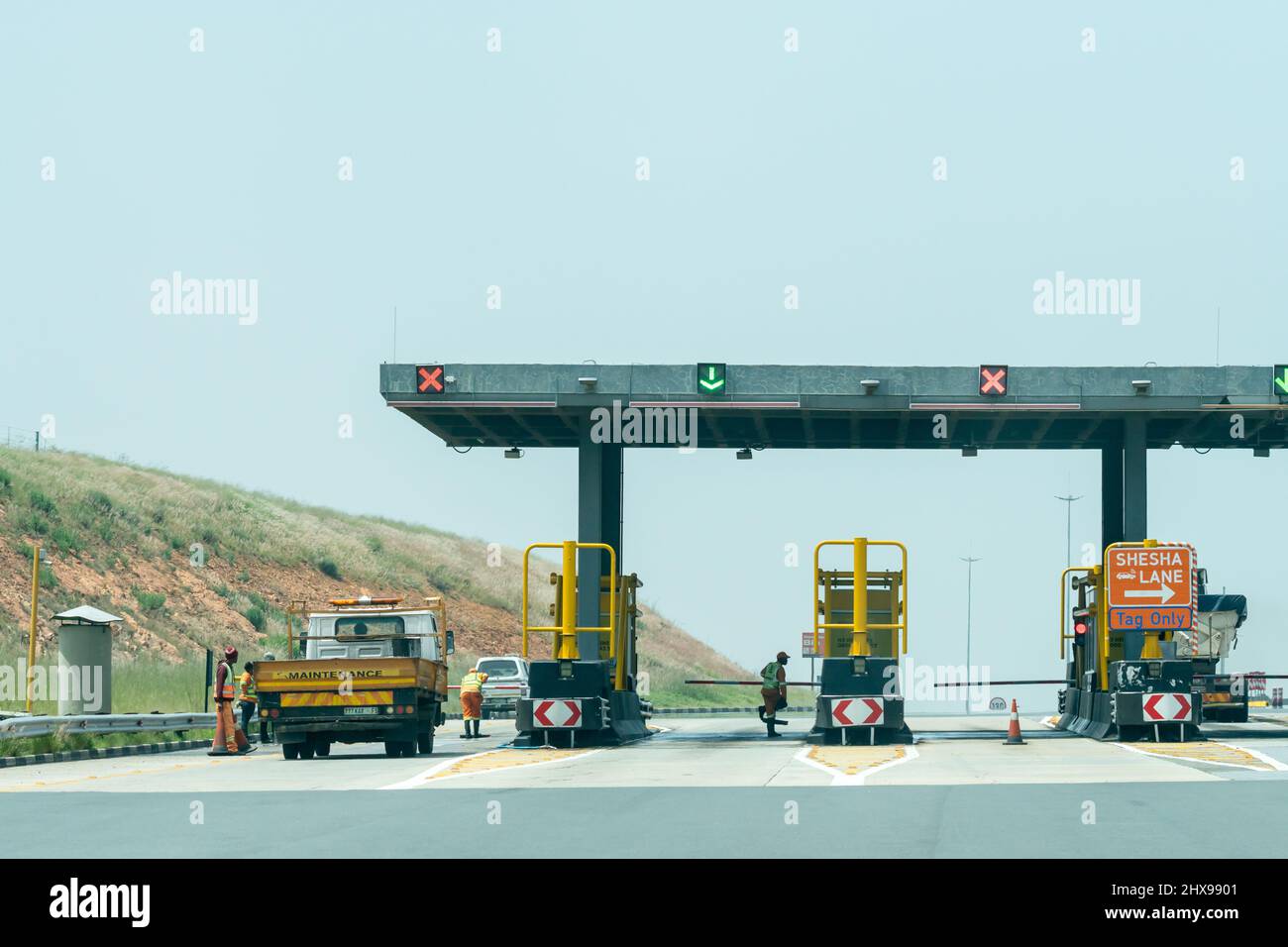 Manutenzione di veicoli stradali e lavoratori in un casello plaza su un'autostrada in Free state, Sud Africa Concept Infrastructure Foto Stock
