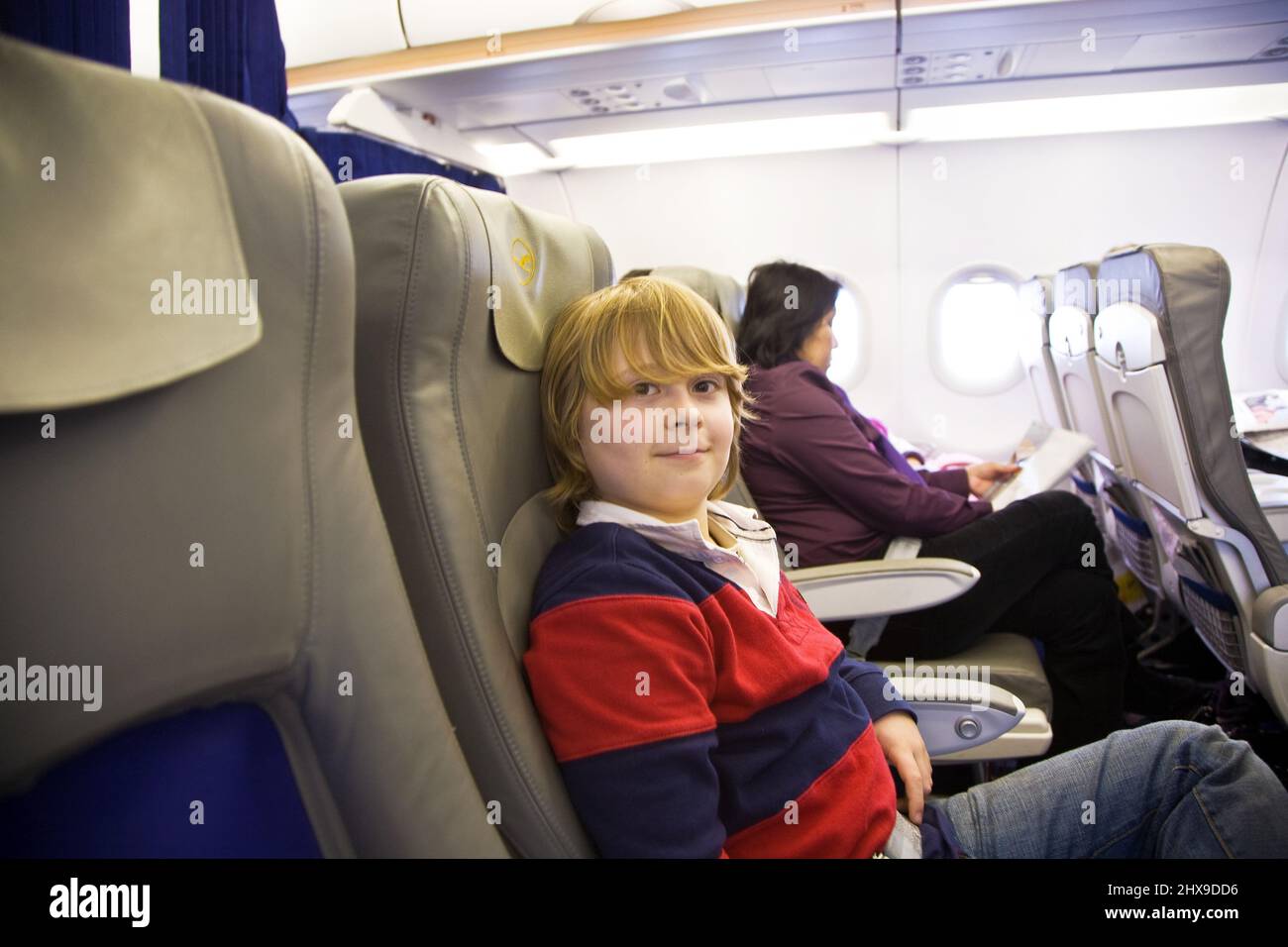 Ragazzo gode di volare in Business Class a bordo dell aeromobile Foto Stock