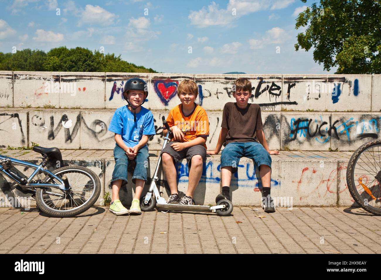 Tre amici rilassarsi da skateboard e BMX la guida Foto Stock
