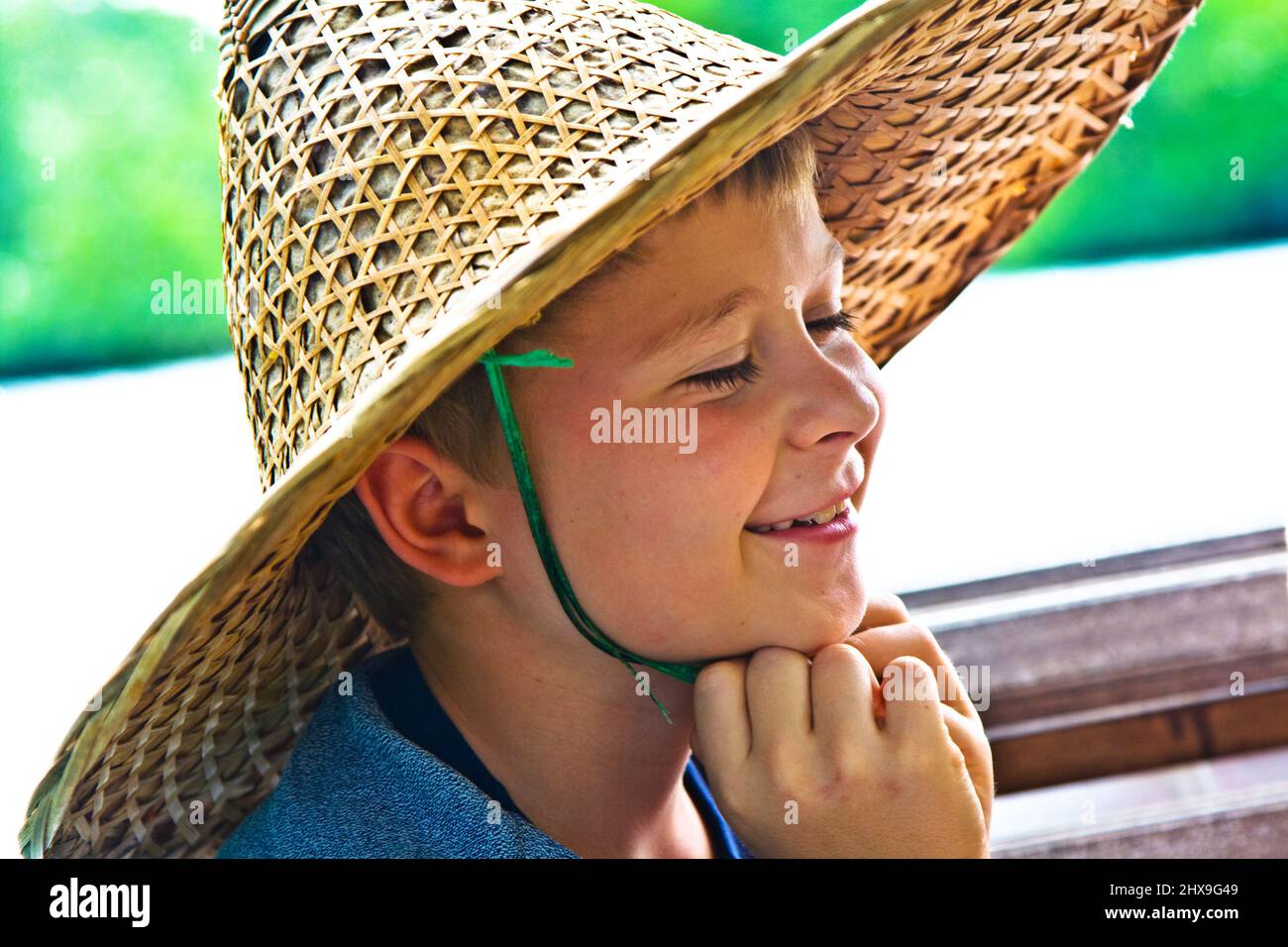Boattrip, bambino sta indossando un cappello fatto di bambù per essere protetti dal sole in Asia Foto Stock