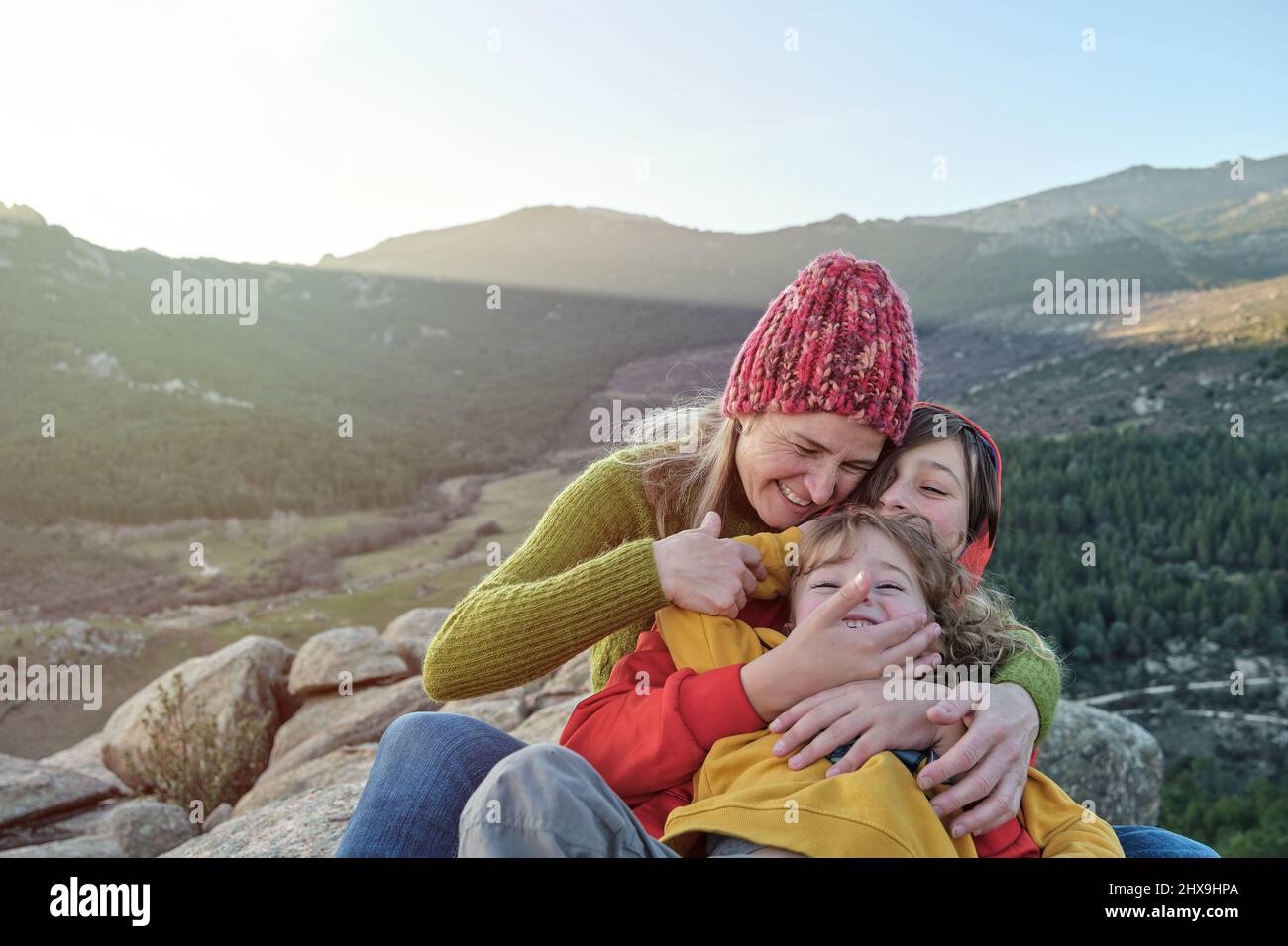 Una madre e bambini giocano e abbracciano la natura Foto Stock