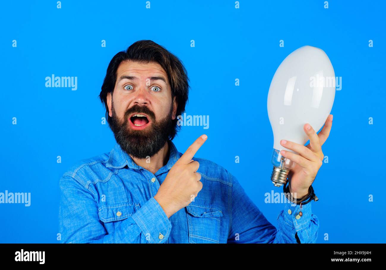 Nuova idea creativa. Uomo sorpreso con lampadina. Brainstorming, ispirazione. Energia ed elettricità Foto Stock