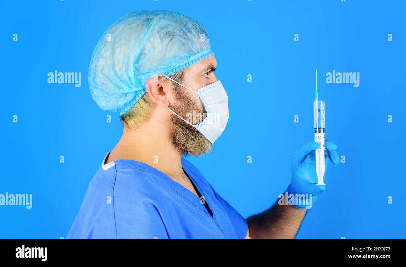 Medico in maschera medica con siringa preparazione per l'iniezione. Vaccinazione per le persone. Medicina. Foto Stock
