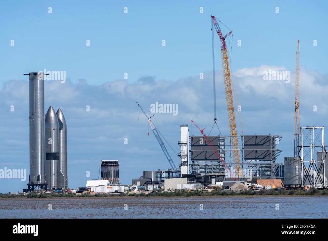 Due prototipi Starship e un razzo Super Heavy Booster cilindrico presso lo stabilimento di assemblaggio SpaceX di Boca Chica, Texas. Lo Starship è alto 160', Foto Stock
