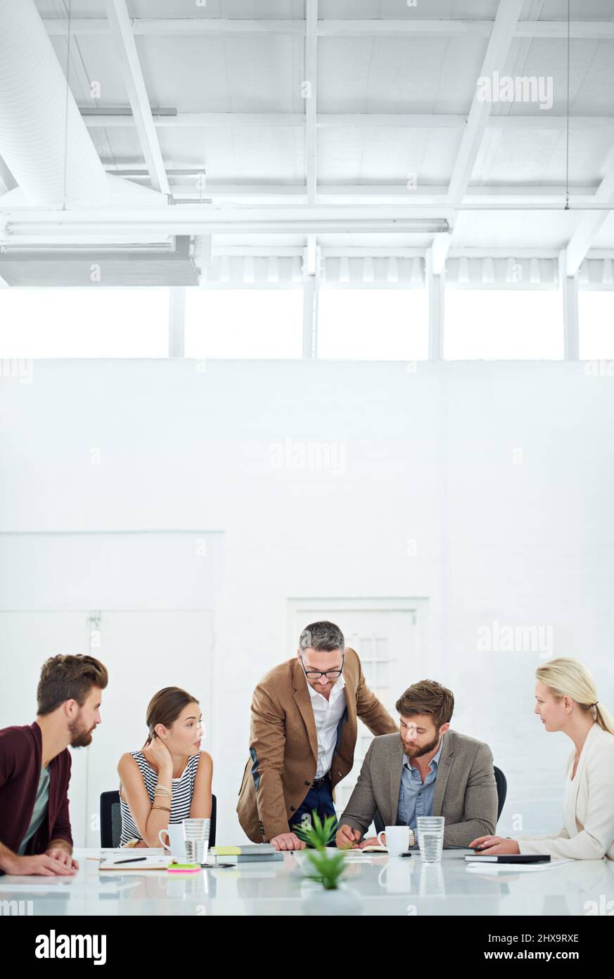 Brainstorming per il successo futuro. Un gruppo di colleghi in piedi attorno a un tavolo. Foto Stock