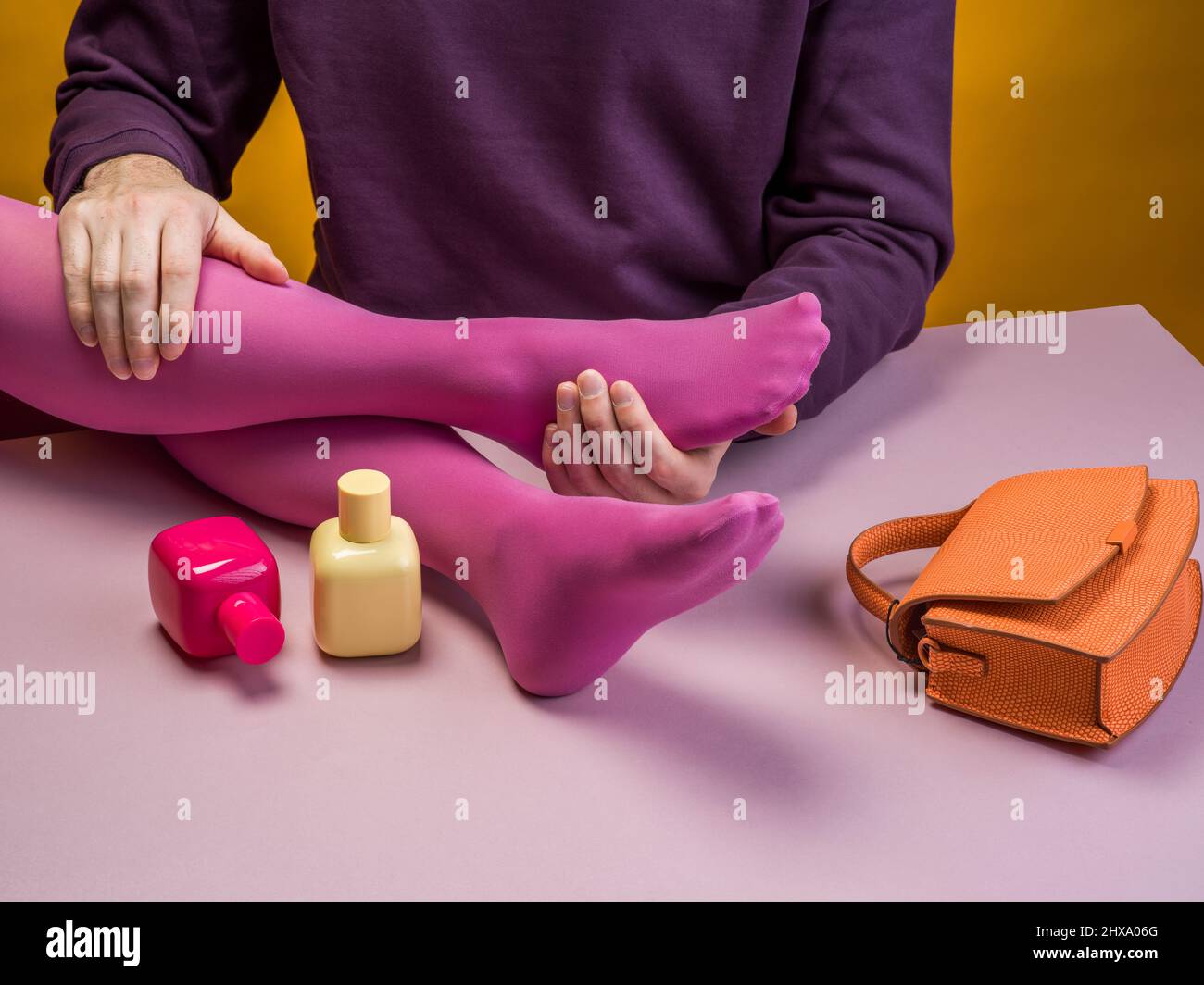 Uomo che tiene le gambe di una donna in collant rosa Foto Stock