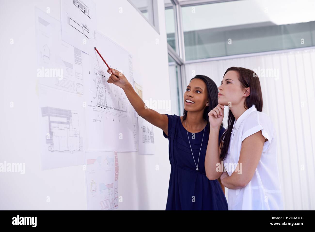 Esperti al lavoro. Foto di due architetti femminili che esaminano i piani di costruzione. Foto Stock