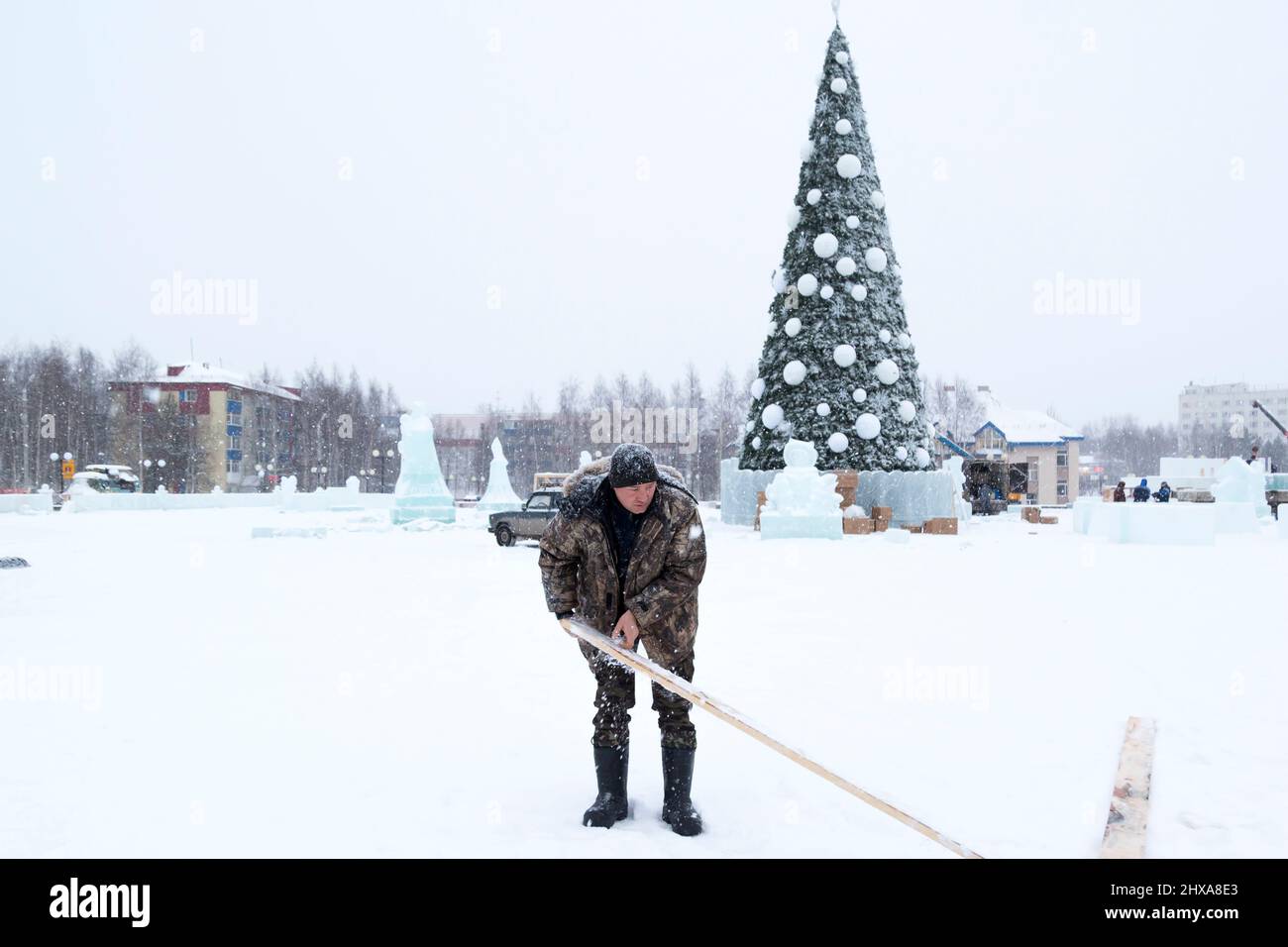 Costruttore con un bordo nelle sue mani sullo sfondo dell'albero di Natale Foto Stock