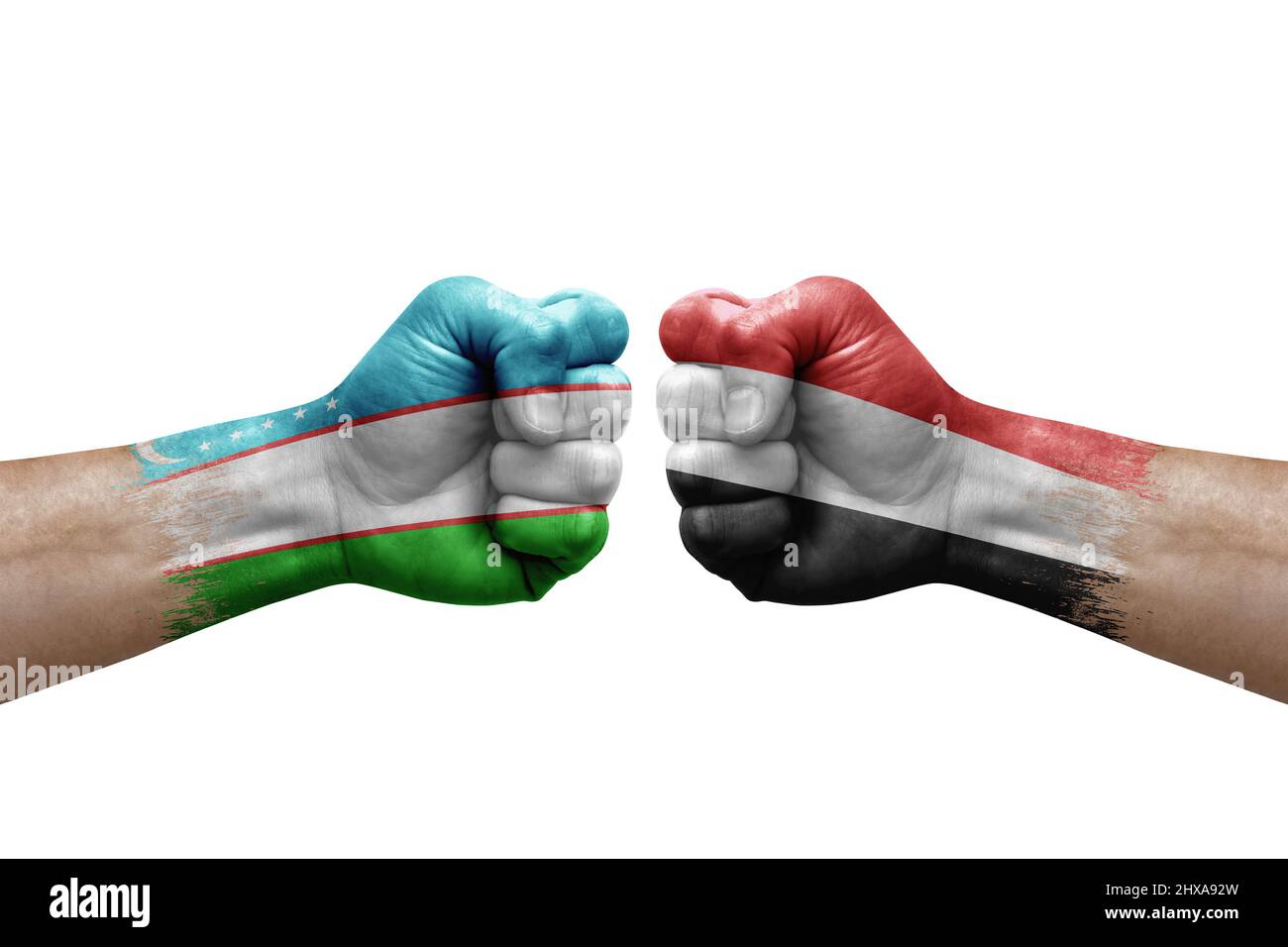 Due mani si pugno l'una all'altra su sfondo bianco. Bandiere di paese dipinte pugni, conflitto concetto di crisi tra uzbekistan e yemen Foto Stock