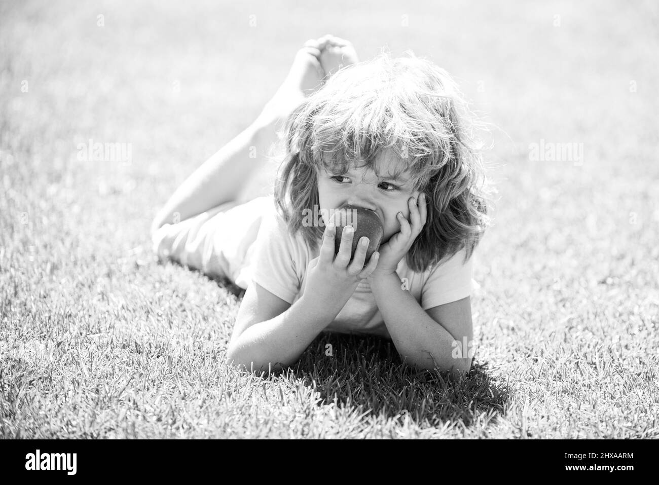 Il bambino mangia la mela. Nutrizione sana del ragazzo per i bambini. Spuntino di frutta. Ora di pranzo. Foto Stock