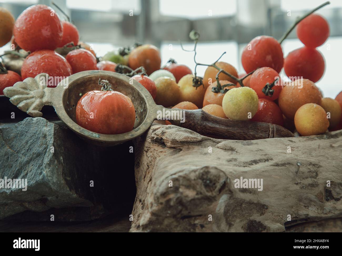 Gruppo di variegata varietà di pomodori freschi (Mini Cherry Tomatos) su vecchio sfondo di legno tavola. Messa a fuoco selettiva. Foto Stock