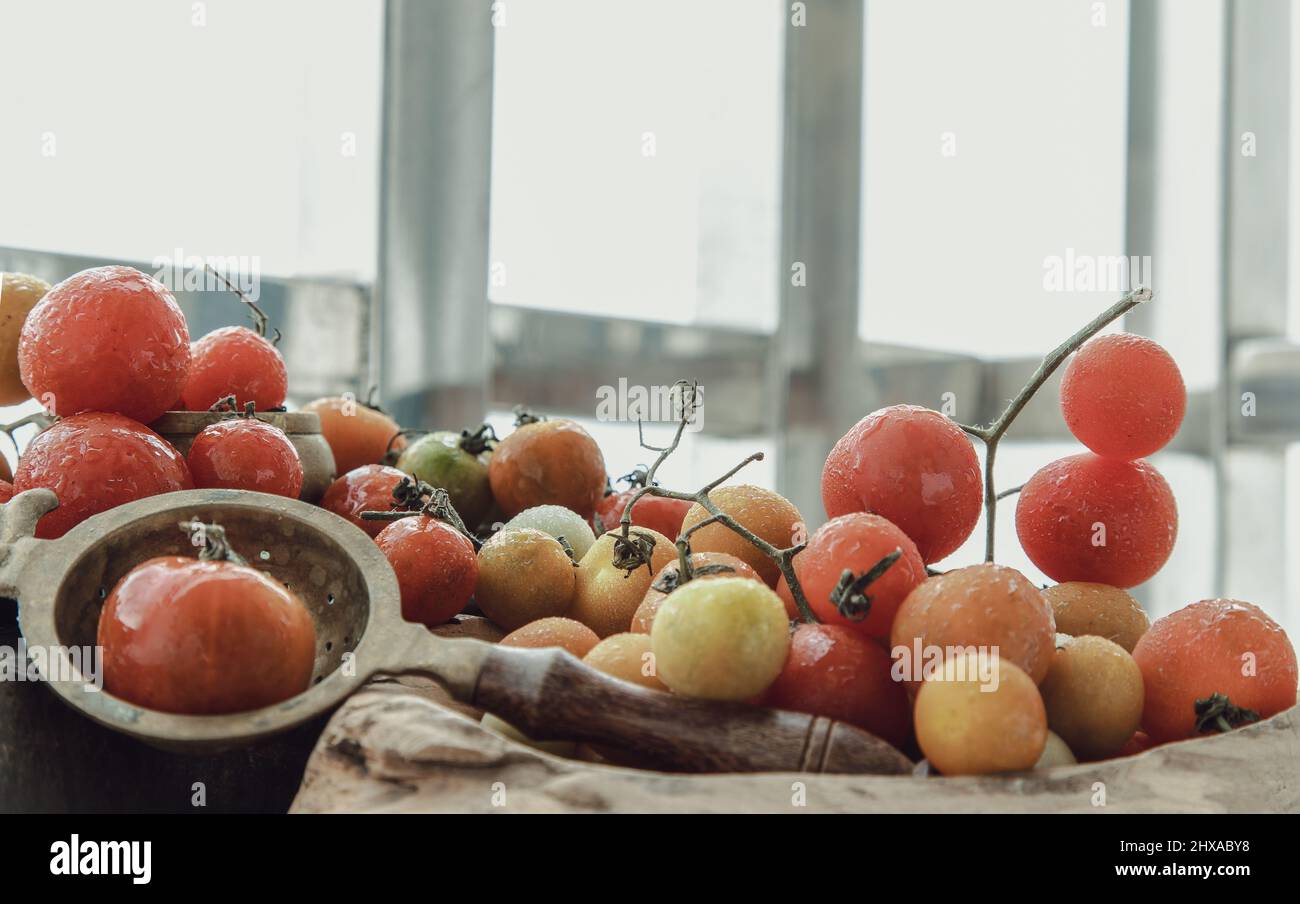 Gruppo di variegata varietà di pomodori freschi (Mini Cherry Tomatos) su vecchio sfondo di legno tavola. Messa a fuoco selettiva. Foto Stock