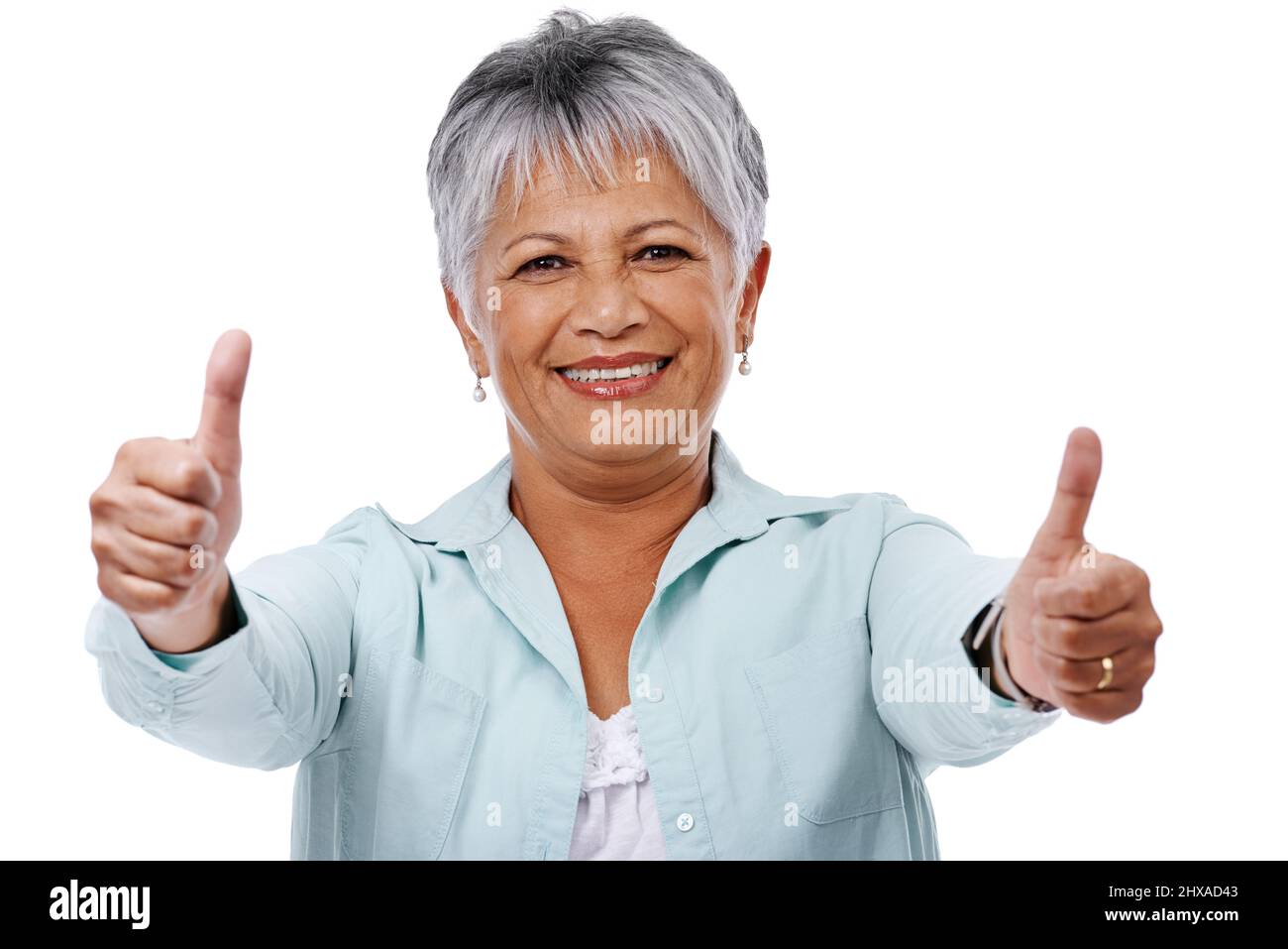 Stile di vita maturo. Studio girato di una donna matura dando i pollici su isolato su bianco. Foto Stock