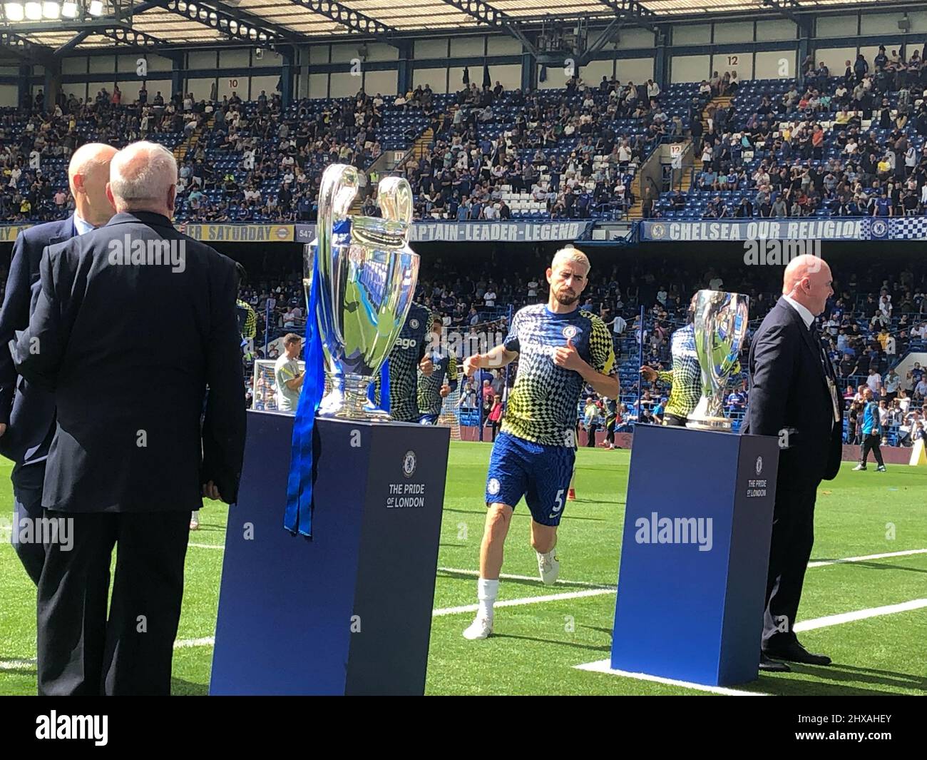 Fulham, Londra, UK14th agosto 2021 Team Vice Captain, Jorginho, corre fuori campo a Stamford Bridge, la sede del Club europeo di CALCIO dei campioni DEL CHELSEA, mentre il club itÕs la prima partita della stagione 2021/2022 nella Premier League, contro il Crystal Palace FC. Qui il Champions League Trophy (vicino) e la UEFA Super Cup in mostra per Jorginho da ammirare mentre entra in campo Foto Stock