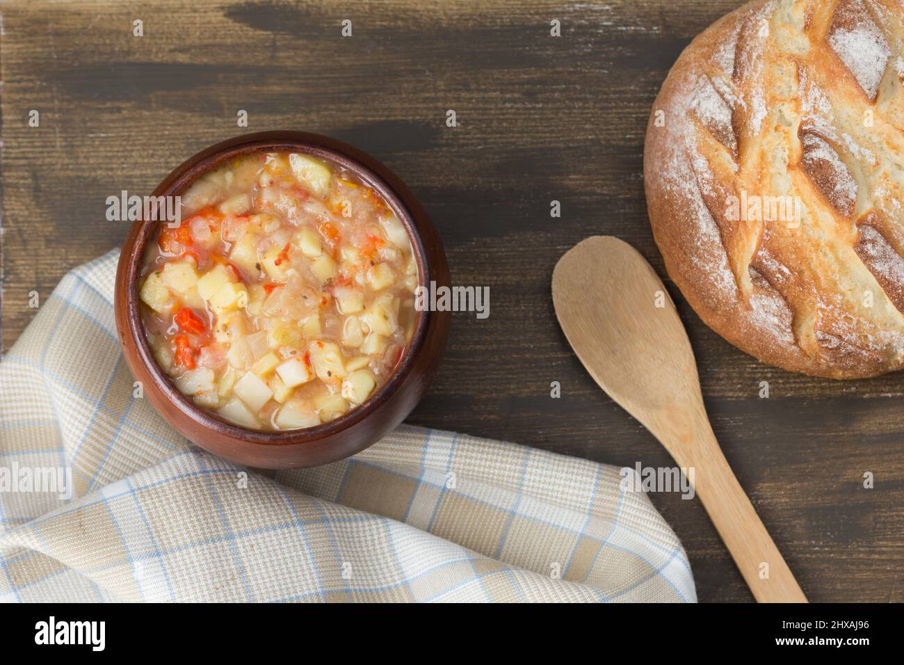 Vista dall'alto di patate e verdure stufato cotto in pentola di argilla su sfondo di legno Foto Stock