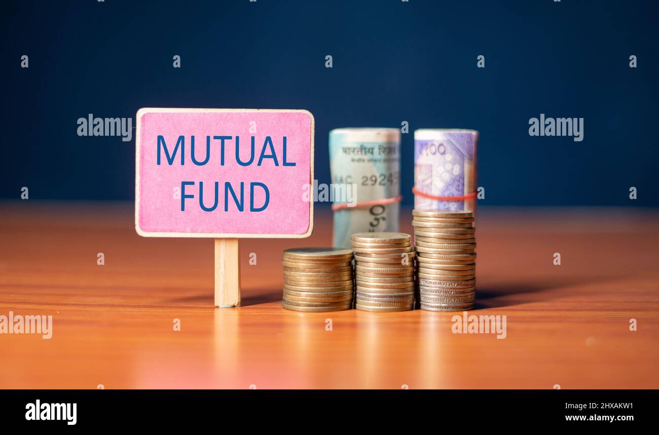 Cartello fondo comune con monete in crescita e stack di denaro - concetto di investimento, risparmio e creazione di ricchezza. Foto Stock