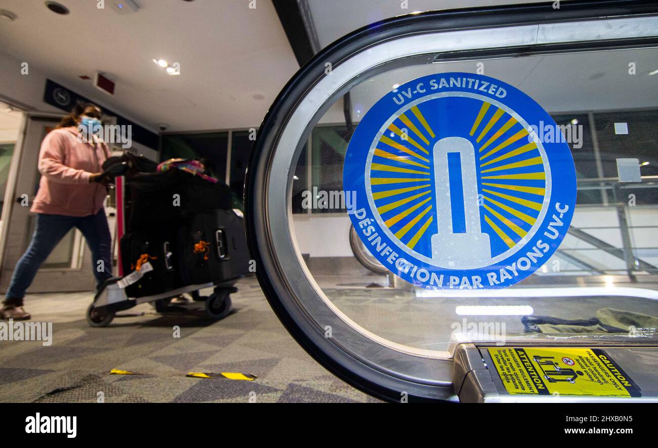 Mississauga, Canada. 10th Mar 2022. Un viaggiatore spinge un carrello bagagli oltre un ascensore con un cartello "UV-C SANITIZED" all'aeroporto internazionale Pearson di Toronto a Mississauga, Ontario, Canada, il 10 marzo 2022. Credit: Zou Zheng/Xinhua/Alamy Live News Foto Stock