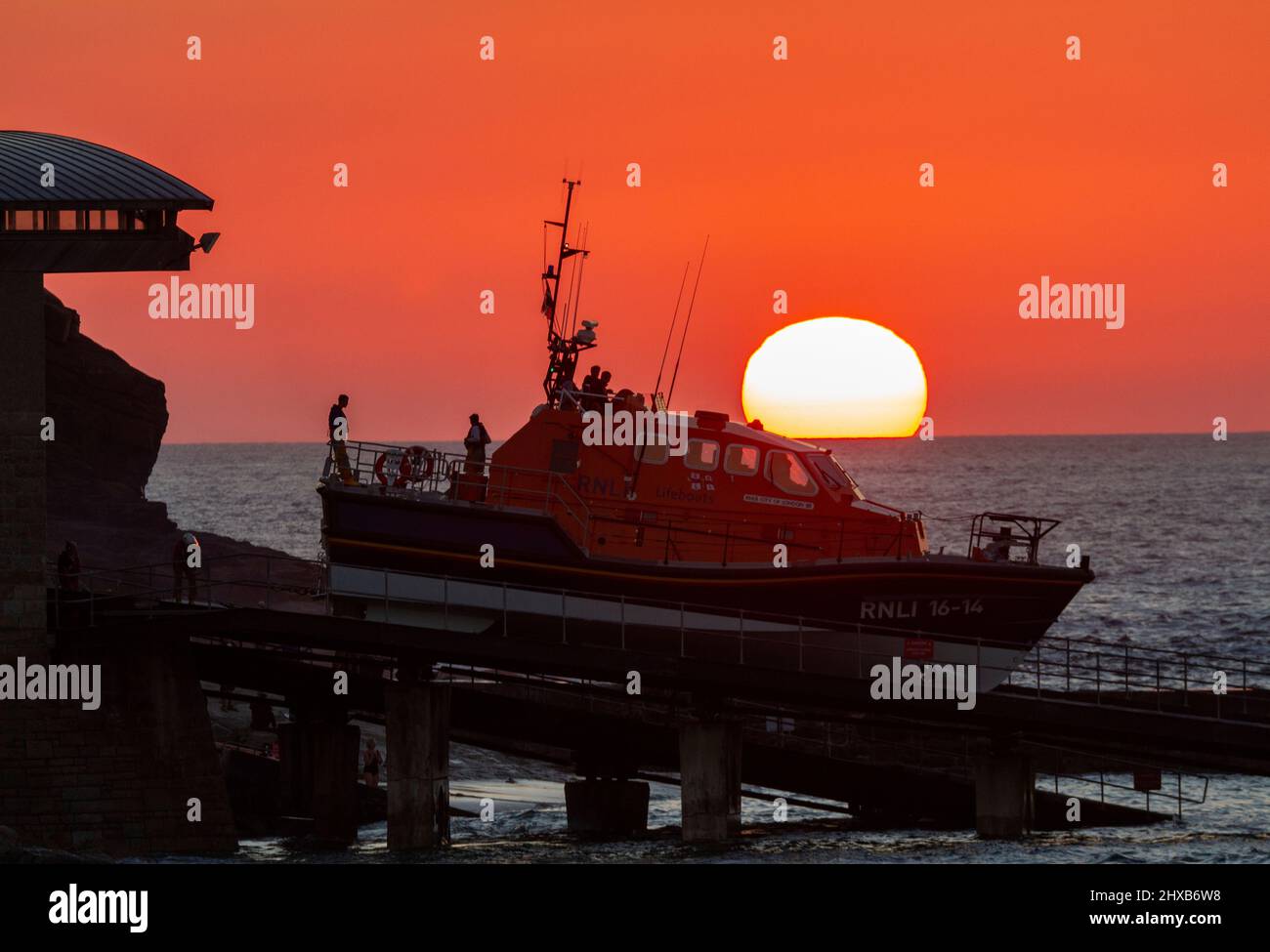 Sennen scialuppa di salvataggio lancia al tramonto su una serata di formazione Foto Stock