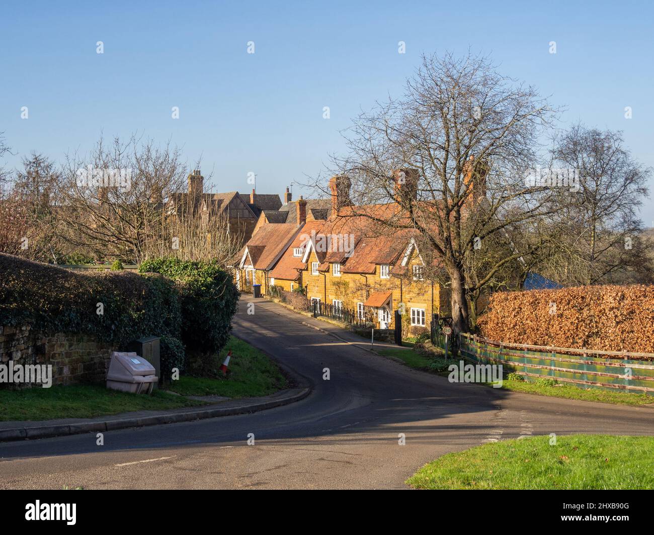 Scena stradale in inverno sole nel villaggio di Great Brington, Northamptonshire, Regno Unito Foto Stock