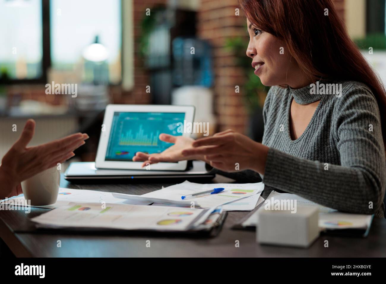 I responsabili esecutivi che guardano le statistiche di marketing che analizzano i grafici sul computer tablet mentre lavorano al progetto aziendale nell'ufficio di startup. Businesswomen idee di brainstorming per la strategia aziendale Foto Stock