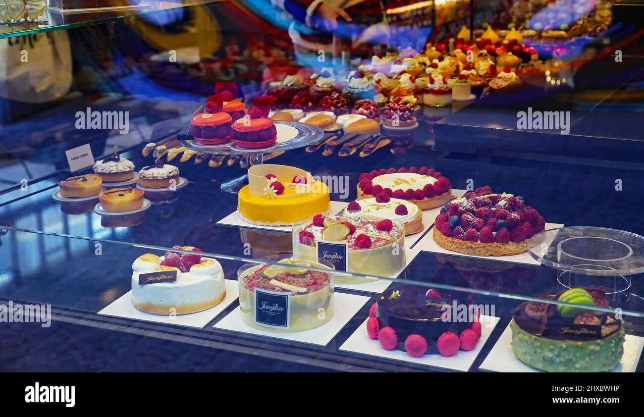 Liegi, Belgio - Marzo 5. 2022: Vista attraverso la vetrina del tipico negozio di confetteria belga con crostate colorate (focalizzazione sulla torta gialla) Foto Stock