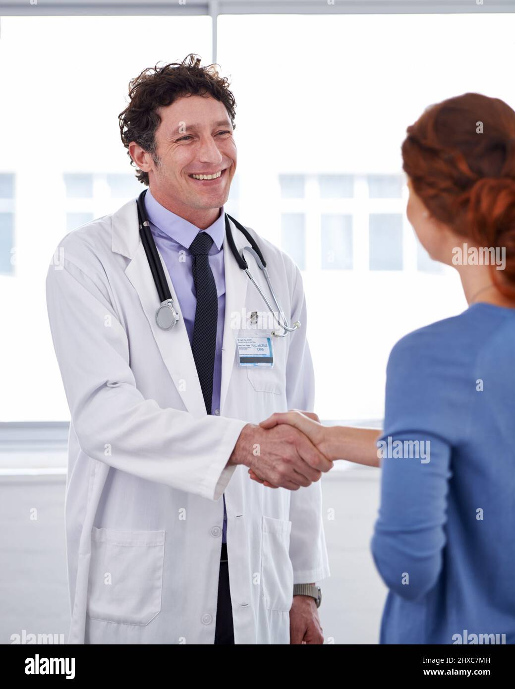 Ha un buon modo di comodino. Scatto corto di un medico e scuotendo la mano dei pazienti. Foto Stock