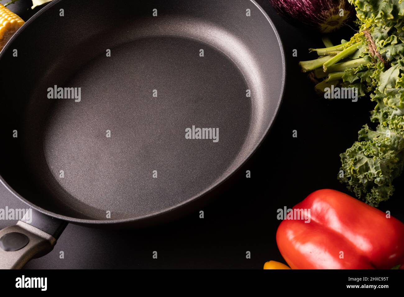 Primo piano della padella nera vuota di kale e peperone rosso sul tavolo Foto Stock