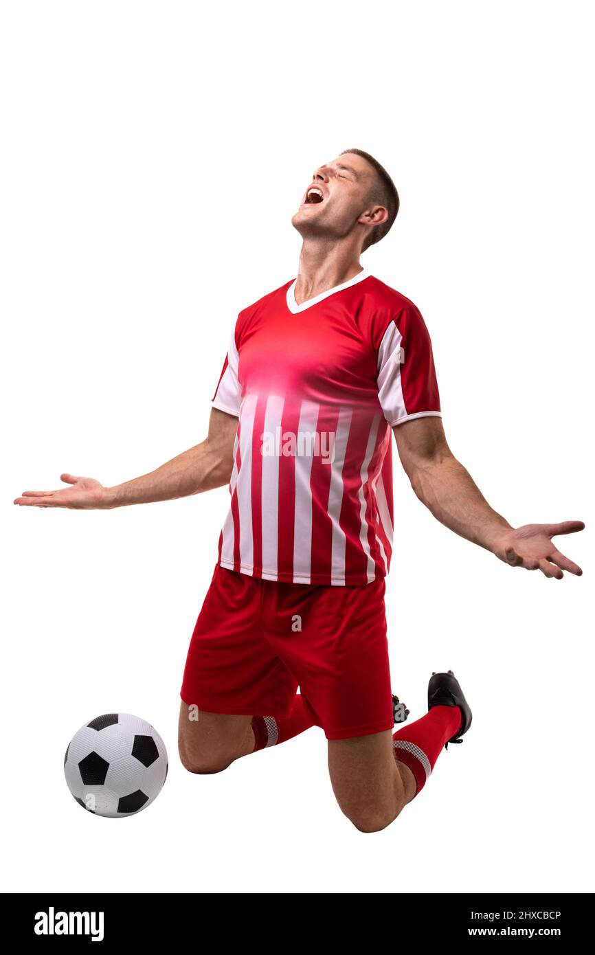 Giovane calciatore caucasico maschio che celebra il gol con la palla su sfondo bianco. Inalterato, sport, competizione e concetto di partita. Foto Stock