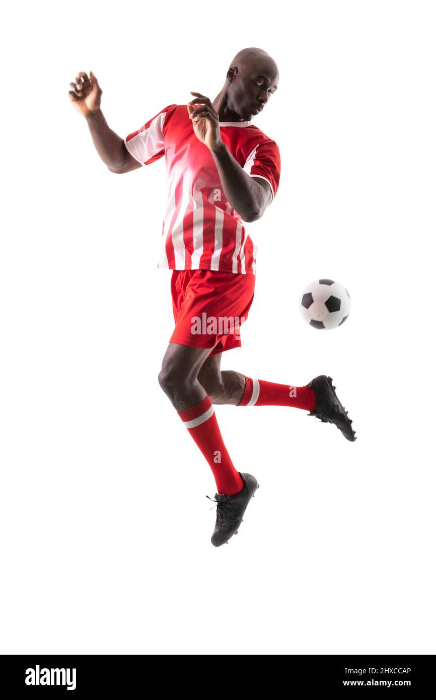 Giovane giocatore di calcio maschile africano americano che controlla la palla su sfondo bianco Foto Stock