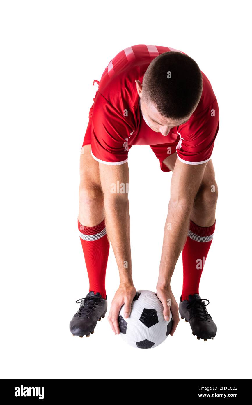 Giovane giocatore caucasico maschio che tiene la palla di calcio posizionamento su sfondo bianco. Inalterato, sport, competizione e concetto di gioco. Foto Stock