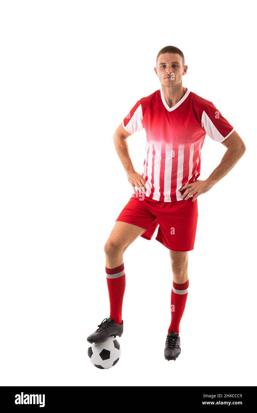 L'atleta caucasico maschile sicuro che si è fatto un passo sulla palla da calcio su sfondo bianco Foto Stock