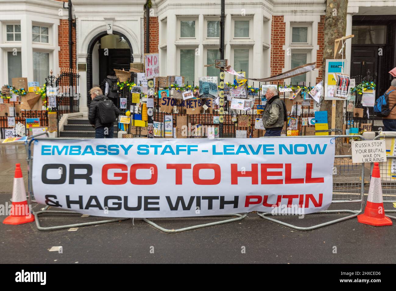 Londra, Regno Unito. 11 marzo 2022. I manifestanti si riuniscono fuori dall'ambasciata russa a Londra, esponendo cartelli e striscioni anti-guerra che condannano l'invasione russa dell'Ucraina. I messaggi includono “personale dell’ambasciata – lascia ora o vai all’inferno e all’Aia con Putin” e “Russia Stop Your Stupid Wars”. La protesta presenta bandiere ucraine e cartelli fatti a mano attaccati a ringhiere e banchi di cartone. Messaggi e manifesti contro la guerra Ucraina sono lasciati sulla ringhiera fuori dall'ambasciata russa a Holland Park. Penelope Barritt/Alamy Life News Foto Stock
