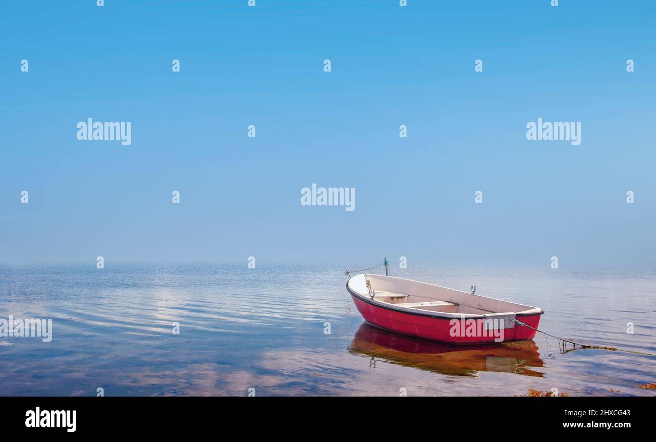Barca a remi rossa in un'acqua calma Foto Stock