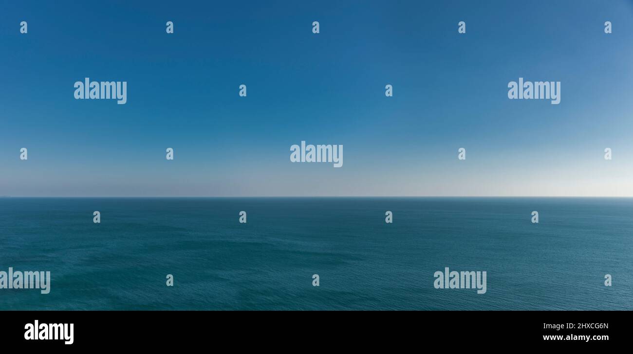 Orizzonte sull'acqua con mare blu e cielo blu Foto Stock